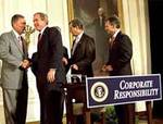 Bush da la mano al congresista Oxley durante la firma de la ley Sarbanes-Oxley